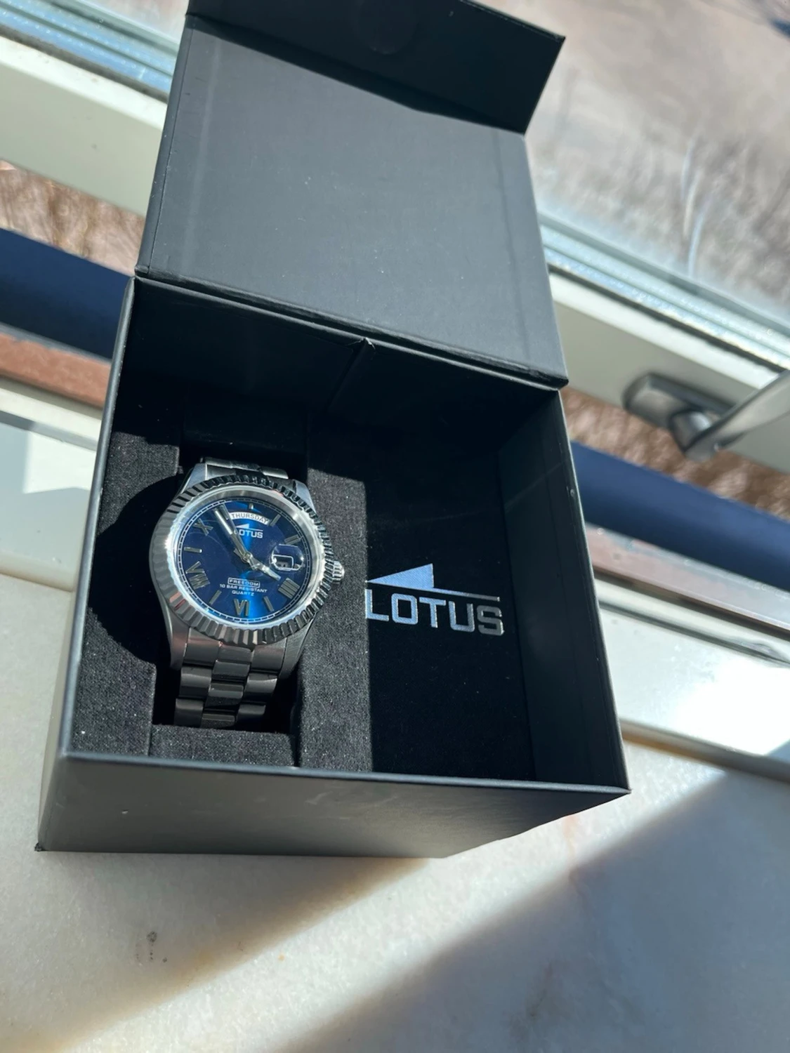 Silverfärgad Lotus klocka med blå urtavla