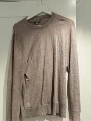 Beige slim fit tröja från H&M - Säljer en beige långärmad tröja från H&M i slim fit-modell. Tröjan har rund halsringning och ribbade muddar vid ärmslut och nederkant. Perfekt för lager på lager och enkel att matcha med olika outfits.matrialet är med 15% cashmire och priset kan diskuteras. 
