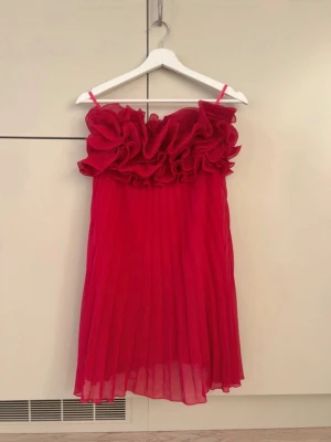 Röd volangklänning med plisserad kjol - Jag söker denna klänningen i storlek xs/S skriv gärna om du har en🫶🏻