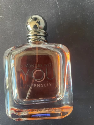 Stronger With You Intensely parfym - Stronger With You Intensely från Emporio Armani är en parfym i en elegant, fyrkantig glasflaska med rundad silverfärgad kork. Doften har en djup bärnstensfärg och flaskan har tydlig logotyp framtill. Perfekt för dig som gillar exklusiva och intensiva dofter.