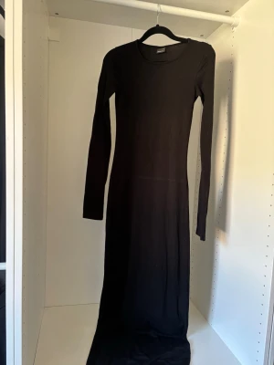 Svart långklänning Gina tricot  - Tight långklänning med slits i ärmarna, säljs inte längre. Sömmarna i ena armhålan har töjts ut lite vilket syns på sista bilden annars i bra skick