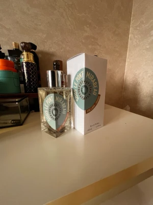 Sous Le Pont Mirabeau Eau de Parfum - Sous Le Pont Mirabeau Eau de Parfum från Etat Libre d'Orange. Flaskan är transparent med silverfärgat lock och har en modern, fyrkantig form. Etiketten är mintgrön och vit med tydlig logga. Kommer i originalkartong med samma design.