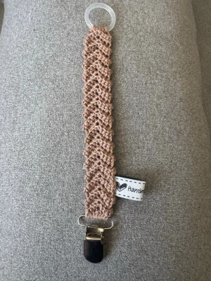 Virkad napphållare - Virkad, ljusbrun napphållare, virkad av mig i 100% bomullsgarn med metallclips och silikonring.  Mönsterskapare: animo.design