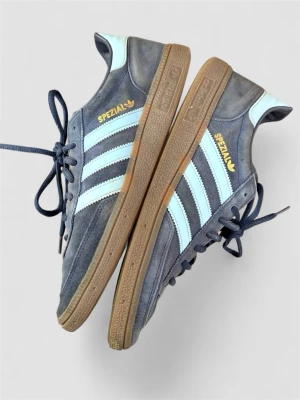 Adidas Spezial blå sneakers - Säljer ett par Adidas Spezial sneakers i blått mocka med ljusblå detaljer och klassiska vita stripes på sidan. Skorna har en låg profil och bruna gummisulor. Perfekt för dig som gillar retrostil och ikoniska märken.