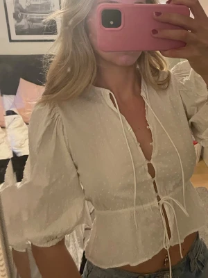 Söt topp - Superfin topp som inte kommer till användning. Den har puffärmar och knappar fram till. Snöre både i midjan och upptill som kan justeras!