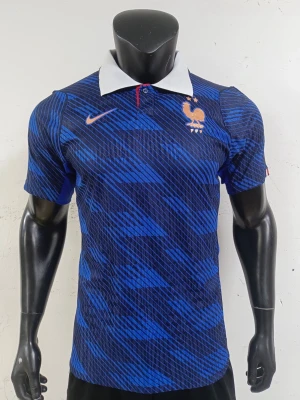 Frankrike Nike fotbollströja blå - Blå fotbollströja från Nike med Frankrikes landslagsmärke på bröstet. Tröjan har korta ärmar, vit krage och ett mönster i olika blå nyanser. Perfekt för fotbollsträning eller att bära när du hejar på laget.