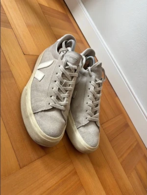 Grå Veja sneakers i mocka Storlek 42  - Säljer ett par Veja sneakers i grå mocka (suede), storlek 42. Skorna är använda men i bra skick – väl omhändertagna och fortfarande mycket kvar att ge.  Den grå färgen gör dem enkla att matcha och passar till de flesta outfits. Bekväma och stilrena sneakers med hållbar design, perfekta för vardag.
