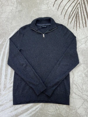 Jack & Jones half-zip tröja - Klasyczny, dzianinowy sweter od Jack & Jones w stylowym szarym kolorze. Model posiada praktyczny zamek błyskawiczny przy kołnierzu, który ułatwia stylizację zarówno na eleganckie okazje, jak i na co dzień. Idealny zarówno na co dzień, jak i na nieco bardziej eleganckie okazje. Wykonany z miękkiej i wygodnej mieszanki:  • 60% bawełny • 20% nylonu • 20% wiskozy  Sweter jest w rozmiarze S i ma standardowy krój.  ✨ Idealnie pasuje do jeansów, tworząc stylowy look!