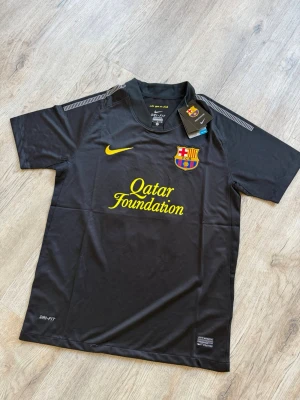 Retro Fc Barcelona 13/14 Bortatröja – Lionel Messi 10 – Ny med tags - Svart bortatröja från FC Barcelona med Lionel Messi tryck (nr 10). Nike Dri-FIT material för bra komfort.           Pris går att diskuteras!!! Aldrig använt, Ny med tags, Snabb leverans, Packas noggrant. Skriv gärna om du har några frågor! Storlek:S