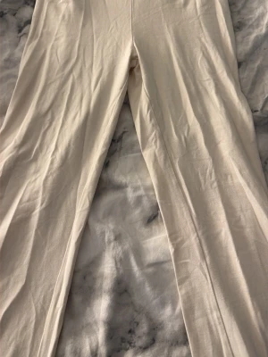krämvita yoga pants - Säljer ett par beiga leggings med ribbad struktur. De har hög midja och är tillverkade i ett mjukt, stretchigt material som sitter skönt mot kroppen. Perfekta att matcha med oversized tröjor eller hoodies.