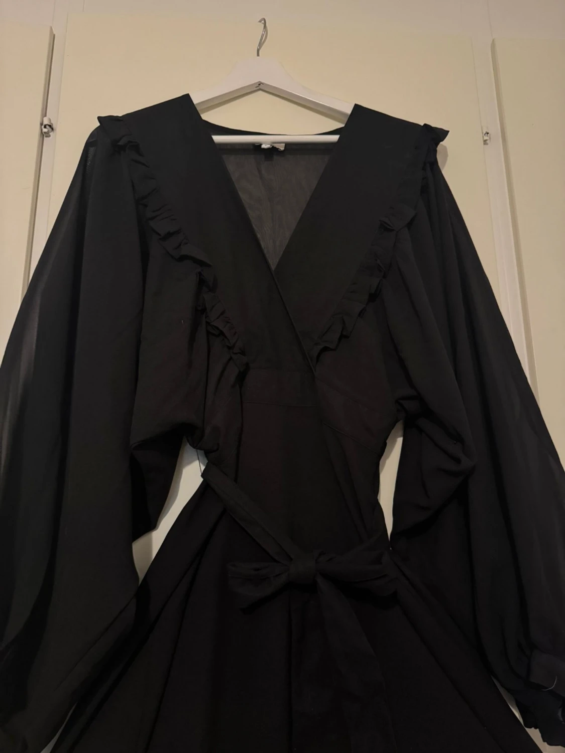 Svart omlottklänning med volang