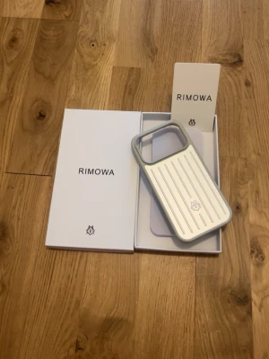Rimowa mobilskal iPhone 17 Pro - Snyggt och stilrent mobilskal från Rimowa i silver med klassiska räfflade linjer. Skalet har en robust känsla och är gjort i ett hårt material som skyddar mobilen. Passar perfekt för dig som gillar exklusiv design och vill sticka ut med ett premiumskal.