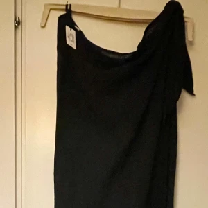 *NY*Svart lång sarong IC Beach Club fr Bik Bok  - Köpte fel stl. Ny med lapp. Perfekt för stranden. Längre sarong i bomullsblandning, kan även användas som klänning beroende på hur du knyter den. Nypris: 279 sek, Pris nu: 65 sek. Perfekt för strandhäng och chill dagar. Enkel och stilren look som är lätt att matcha med accessoarer. Tvättas i 30c, kan strykas på låg temp, ej torktumlas. 