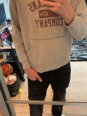Grå hoodie från Ralph Lauren - Säljer en grå hoodie från Ralph Lauren Polo Jeans Company med röd logga på bröstet. Hoodien har en stor magficka och ribbade muddar vid ärmar och midja. Storlek L men passar även M, mycket bra skick. Hör av er vid minsta fundering! 