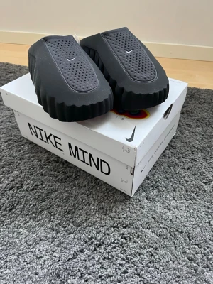 Nike Mind svarta tofflor - Nikes senaste och mest hypade tofflor. Har sålt slut på några minuter de 3 första släppen, säljer dessa då de var för små. Säljs för 2500kr på StockX. Mitt pris 1999kr, det går att diskutera vid snabb affär 