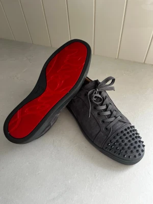 Grå mocka sneakers från Louboutin 45 - Säljer ett par grå sneakers från Christian Louboutin (Extremt väl behandlade). Skorna kommer låda, alla lappar samt dustbags! Fräscha och inga defekter😊! Hör av dig vid frågor, priset är självfallet inte hugget i sten!😊 Säljer pga storleken😊