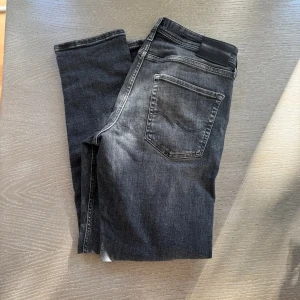 Jacknjones jeans - Snygga svarta jacknjones jeans. Modellen är slim och har klassiska fem fickor, dragkedjegylf och svarta sömmar. Jeansen är tillverkade i mjukt denimtyg som sitter skönt och passar perfekt till sneakers eller boots.