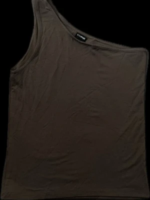 oneshoulder topp  - Säljer en brun oneshoulder topp från Gina Tricot. Toppen är ärmlös och har en asymmetrisk axel. mjukt material som sitter skönt mot kroppen. Använd ca 2 ggr. Inga defekter.