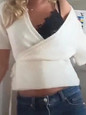 Vit omlottopp med knytband - Snygg vit omlottopp med korta ärmar och knytband i sidan. Toppen har en croppad passform och djup v-ringning. Perfekt att styla med jeans eller kjol för en trendig look.