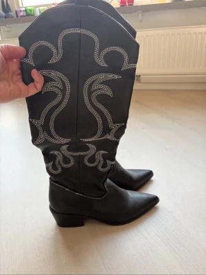 Cowboy boots - Supersnygga svarta cowboyboots med silvrig detalj!! På bilderna ser ni hur höga de är, jag på bilden är 170 cm💖💖💖