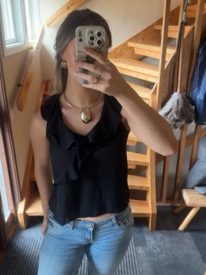 Svart volang topp med v-ringning - Snygg svart ärmlös topp med v-ringning och volangdetaljer framtill. Från Zara ’basic’ kollektion, storlek S 🌸