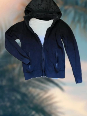Indicode jacka - Väldigt härlig indicode cardigan i svart, perfekt för layering eller kombinera med ett par snygga jeans. 2 ytterfickor i medel storlek och en avtagbarluva dessutom. Inte för varm inte för sval perfekt till höst, vår och sommarkvällar. Väldigt god kvalite har endast används ett dussin gånger och har tagits väl hand om. Hör av er vid frågor eller funderingar.  A=48 cm B=44 cm men är lite strechigt C=41cm D=58cm  Cheers🤘