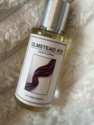 OLMSTEAD 47.0 extrait de parfum - OLMSTEAD 47.0 extrait de parfum från one bold chemist. Använd 2 ggr. Denna doft öppnar med en romantisk blandning av bulgarisk ros, viol och söt jordgubbe, som skapar en mjuk och förförisk inledning. Hjärtat kretsar kring elegansen hos turkisk ros, vilket tillför djup och sofistikering. Basen avslutas med en rik kombination av oud, vanilj, bensoin, amber, karamell och ceder, som lämnar ett varmt och lyxigt spår.