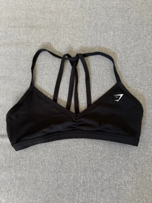 Sport-bh Gymshark - En träningstopp/träningsbh från Gymshark. Avtagbara band så den går att ha som halternecktopp. Storlek S. Lappen är bortklipp men nästintill oanvänd så därav mycket gott skick!🤗