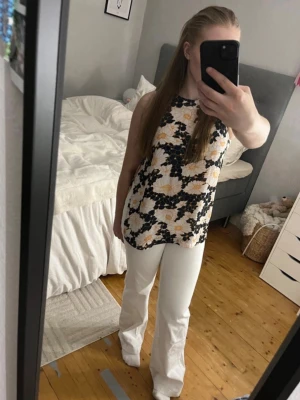 Vita bootcut jeans - Säljer ett par vita bootcut jeans med hög midja och utsvängda ben. Jeansen har en clean look utan slitningar eller detaljer och är perfekta för dig som vill ha en fräsch och stilren vibe. Säljer också toppen! 