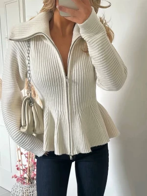 Monki Peplum  - Säljer en snygg vit ribbad tröja med dragkedja framtill och bred krage. Tröjan har figurnära passform och volang nedtill som ger en trendig siluett.  Köpt från monki använd 1 gång 