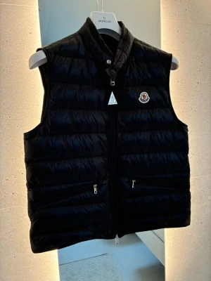 Moncler vest - Saljer en helt oanvand Moncler Gui vast i svart, storlek 3 . Köpt på NK och kvitto finns kvar. Några lappar finns kvar, resten ligger i nk påsen. Aldrig anvand. Perfekt nu till vår/sommar eller som lager på vintern. Väldigt populär modell från Moncler. Skick: 10/10 (helt ny) Nypris: ca 9 000-10 000 kr Mitt pris: 7 999 kr (kan diskuteras vid snabb affar) Hör av dig vid fråga eller fundering eller om du vill ha mer bilder!!😊😊👍