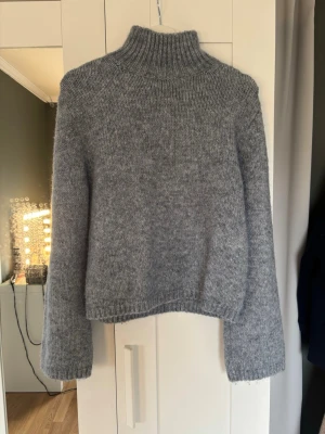 Stickad tröja med högre krage - Säljer denna jättesnygga tröjan från hm då den inte kommer till användning längre!! Färgen är blå/grå (den är mer blå i verkligheten!)❤️