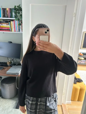 Svart stickad tröja med rund hals - En svart stickad tröja med rund hals och långa ärmar. Tröjan har en enkel och clean look med ribbade muddar vid ärmslut och nederkant. Perfekt att matcha med både jeans och kjol för en chill stil.