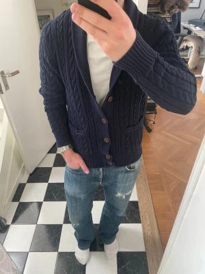 Blå cardigan  - Tja säljer en snygg blå cardigan. Tröjan är i storlek M och sitter bra. Märket är okänt då ja köpt second hand. Modellen är 175 och 72kg. Skriv vid frågor eller funderingar 