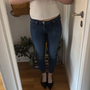 Blå skinny jeans Lee - Säljer ett par blå W28 L33 Scarlett Cropped. Lee Jeans.  Lågmidja och stretchigt material som sitter tight hela vägen ner, med en kort dragkedja vid fotleden. Ursprungspris ca 500kr. 