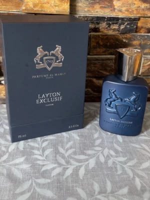 Layton Exclusif Parfums de Marly 75 ml Kvitto finns! - Säljer min exklusiva parfym Layton Exclusif från Parfums de Marly. En lyxig och maskulin doft med djupa, varma toner som verkligen sticker ut.  Flaskan är på 75 ml och det är cirka 73 ml kvar, alltså knappt använd. Kommer med originalförpackning i mycket fint skick.  Perfekt för dig som vill ha en unik och elegant doft till både vardag och speciella tillfällen.  Nypris: 3000