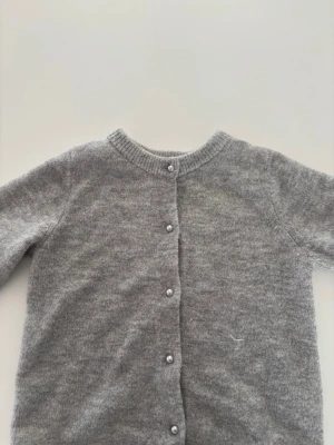 Grå stickad kortärmad med pärlknappar - Stickad kortärmad i grå med vita pärlknappar 