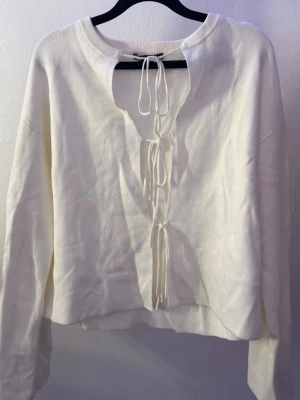 Vit topp med knytning – Gina Tricot - Jättefin vit topp med knytning framtill som ger en lite mer speciell detalj. Väldigt lätt att styla och funkar till både jeans, kostymbyxor eller kjol. Sitter snyggt på och passar till många olika outfits. 