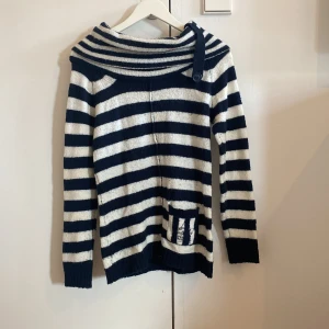 Randig stickad tröja med knappdetalj - Säljer en mysig stickad tröja från Only som är of shoulder med en liten ficka framtill med broderad logga. Står storlek L fast skulle säga storlek S-M🤍💙