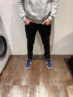 Dondup george - Säljer ett par svarta slim fit jeans med smal passform och klassisk femficksdesign. Jeansen har normal midja och är tillverkade i ett stretchigt material för extra komfort. Perfekta för en clean och stilren look.