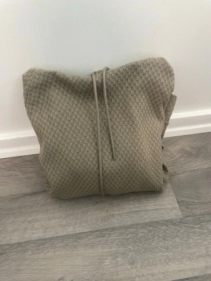 Beige Emporio Armani hoodie - Säljer en stilren hoodie från Emporio Armani i storlek M. Den har en snygg, lite unik struktur i tyget som ger en mer exklusiv känsla än vanliga hoodies.  Beige/sand färg som är lätt att matcha och passar till det mesta. Väldigt fint skick och skön passform. Nypris var betydligt högre - hör av dig vid intresse.