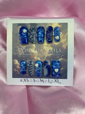 BlueJelly (XS);Medium Square;Curved - Handgjorda press-on naglar i cool blå färg med vita och marinblåa detaljer samt små hjärtan. Mix av mönster med swirl-design. Naglarna har en glansig finish och är i medium square form. Perfekt för dig som vill sticka ut med unika naglar.XS: 14 mm, 11 mm, 11,5 mm, 10 mm, 8 mm 