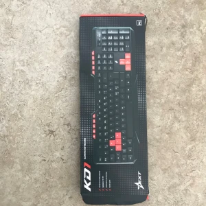 Svart gamingtangentbord från Axt - Gamingtangentbord i svart med röda detaljer på utvalda tangenter. Fullstort tangentbord med klassisk layout, designat för gaming. Tangenterna är markerade med vita tecken och materialet är plast. Snygg och modern look som passar till datoruppsättningen.