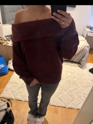 Vinröd off shoulder stickad tröja - Mysig vinröd stickad tröja med bred off shoulder-ringning och långa ärmar. 