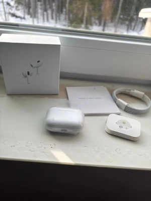 Apple AirPods Pro med laddningsetui - Säljer ett par Apple AirPods Pro2 med vitt laddningsetui, originalkartong, laddkabel och tillbehör. Hörlurarna är trådlösa in-ear-modell i stilren vit färg och har silikontoppar för bekväm passform. Perfekt för dig som vill ha grymt ljud och smidig anslutning till iPhone.