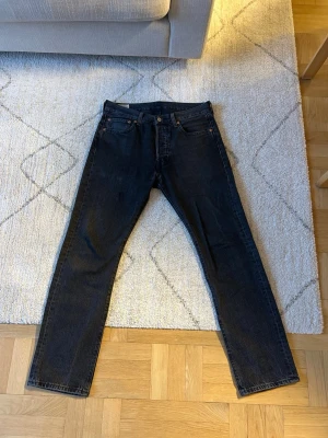 Levi's Premium svarta raka jeans - Snygga svarta jeans från Levi's Premium med klassisk rak passform och fem fickor. Jeansen har kopparfärgade nitar och är tillverkade i slitstark denim. Perfekta för en stilren och tidlös look. Dessa är ganska mycket använda under en period. Några år sedan nu som de användes. 