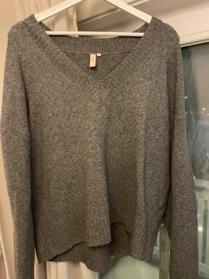 Grå stickad tröja med v-ringning - Mysig grå stickad tröja med djup v-ringning från Nelly