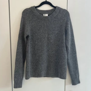 Grå stickad tröja  - Mysig grå stickad tröja från Cubus  med rund halsringning och långa ärmar. Tröjan har en enkel och stilren design med ribbstickade muddar vid ärmslut och nederkant. Perfekt för en avslappnad look.