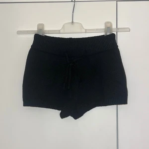Svarta shorts - Mysiga svarta virkade shorts med snörning i midjan. Perfekta för en avslappnad stil och sköna att bära hemma eller till vardags. Kort modell med mjuk känsla.