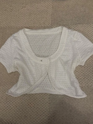 Super söt vit bolero - En jätte fin kort bolero/ kofta med en knapp i mitten man kan knäppa med! Jätte bra för layering och har inga defekter💕 Perfekt för coquette stil !!!! Passar S och XS
